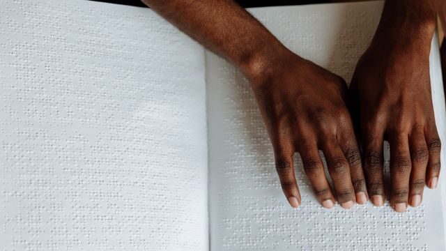 Hand on the book in Braille